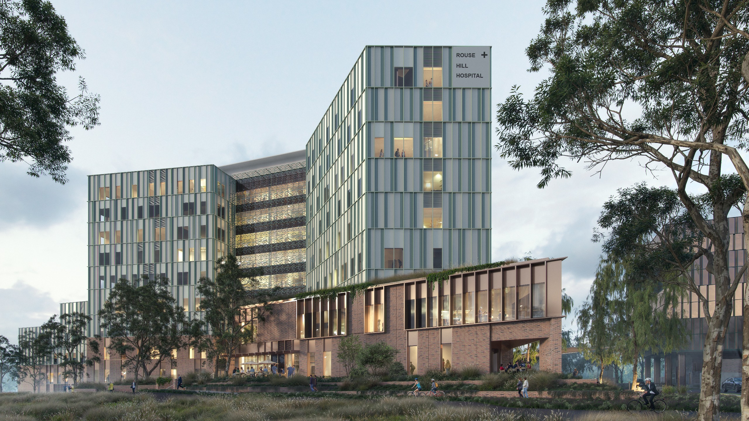 Architectural render of the new Rouse Hill Hospital showing a multi-storey modern healthcare facility with green-tinted facade panels surrounded by native landscaping